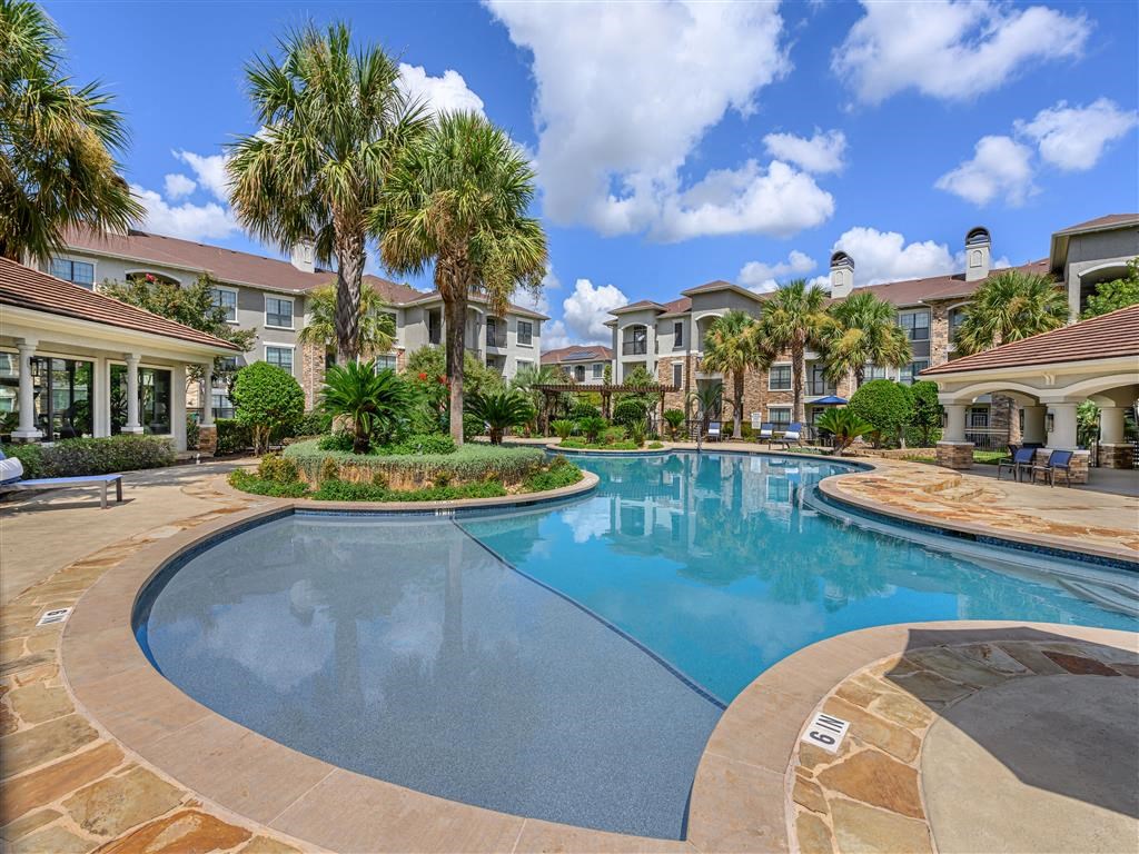 a large swimming pool with houses in the background