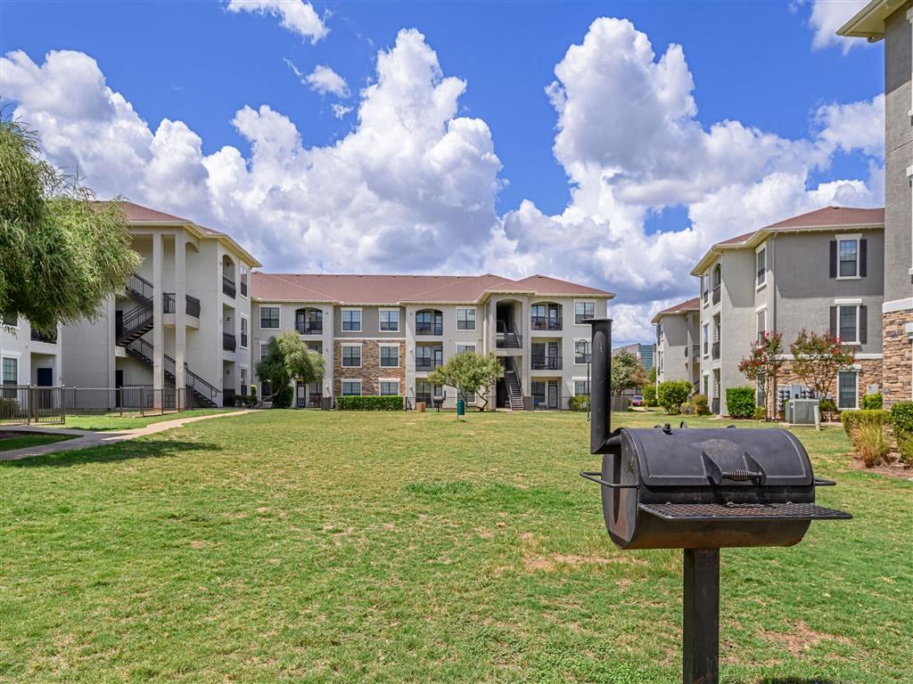 an apartment building with a mailbox in the grass