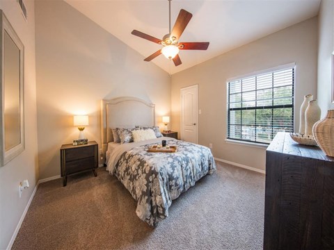 a bedroom with a bed and a ceiling fan