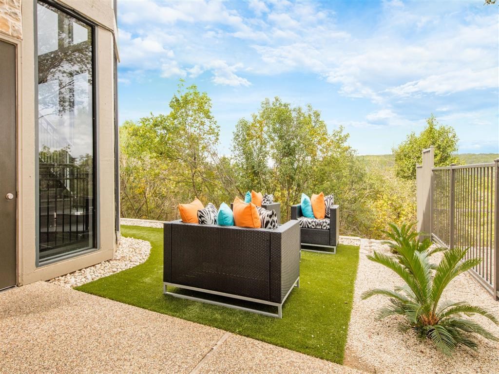 a backyard with a couch and chairs on a lawn