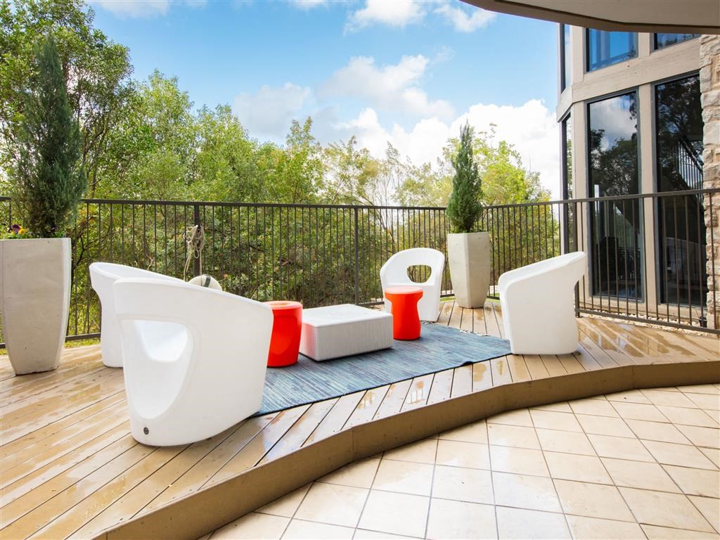 a terrace with a row of urinals and chairs on a balcony
