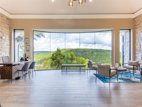 a living room with large windows and a table and chairs