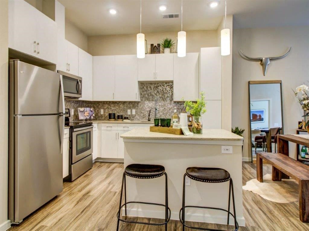 a kitchen with white cabinets and stainless steel appliances