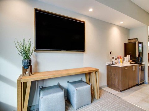 a living room with a tv on the wall and a wooden table