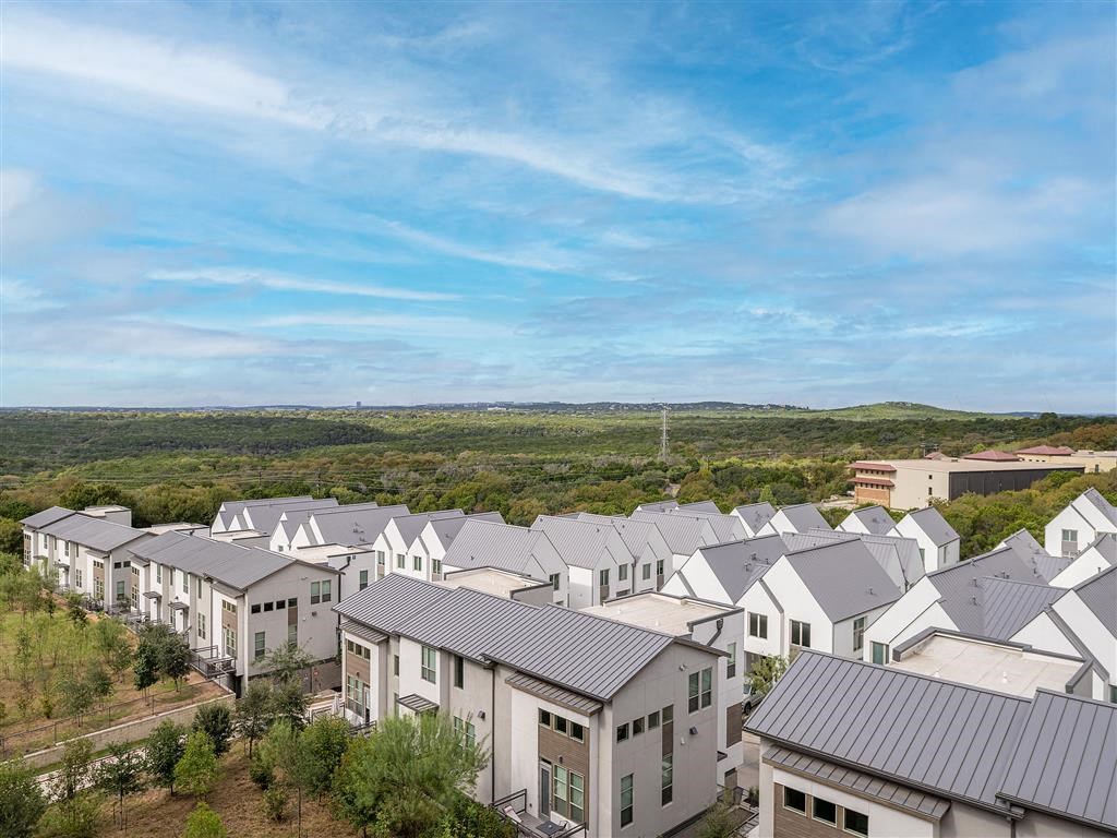 arial view of a housing development with trees and a blue sky