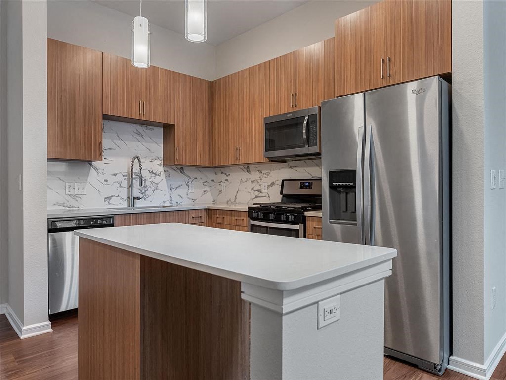 a kitchen with stainless steel appliances and a white counter top