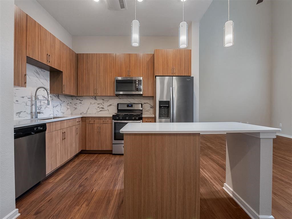 a kitchen with wooden cabinets and stainless steel appliances
