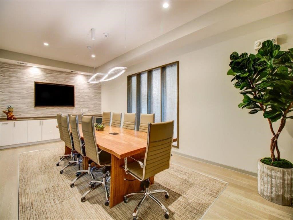 a conference room with a wooden table and chairs and a television