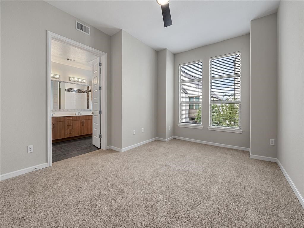 an empty living room with a large window and a bathroom