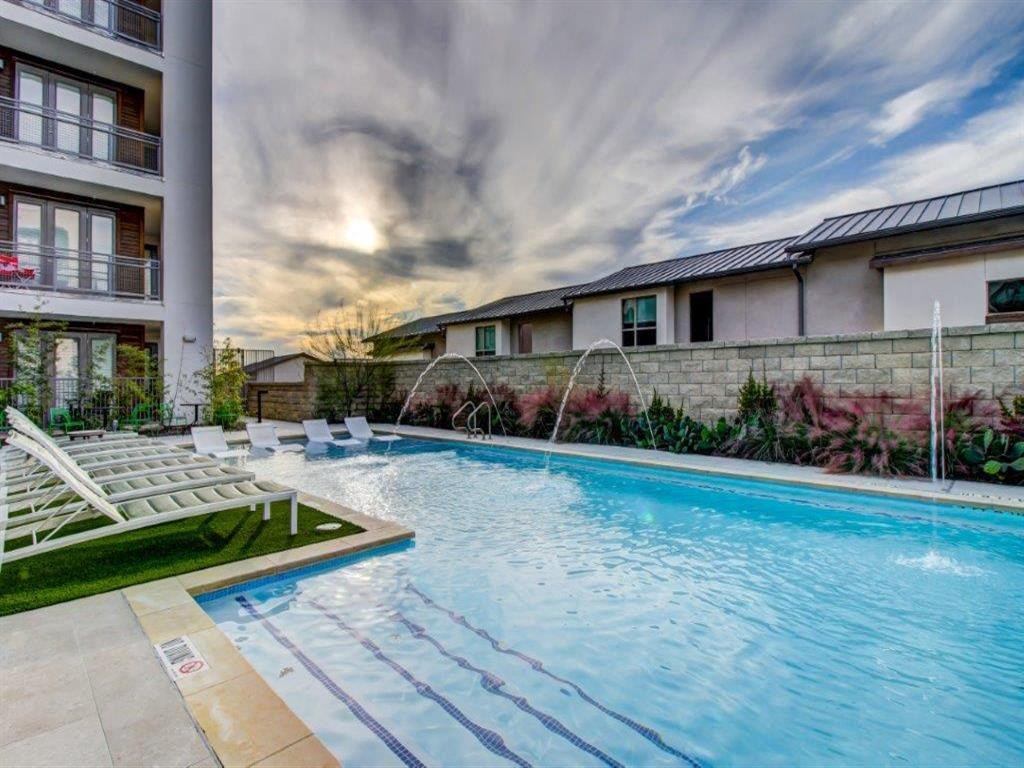 a swimming pool with chairs next to a building
