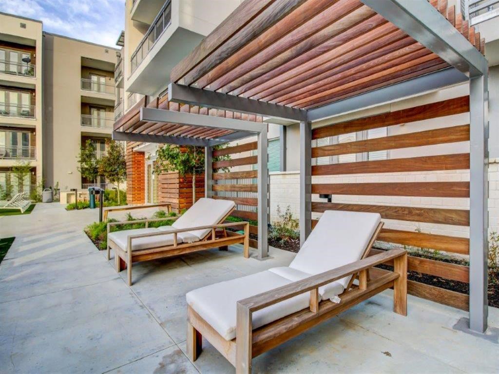 two lounge chairs in front of an apartment building with awning