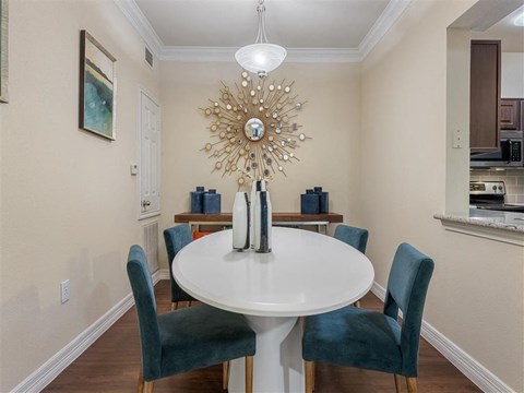 A dining room with a white table and blue chairs.