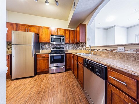 A kitchen with wooden cabinets and stainless steel appliances.