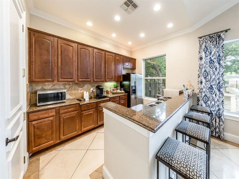 A kitchen with brown cabinets and a granite countertop.