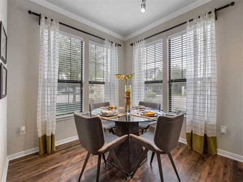 A dining room with a table set for four.