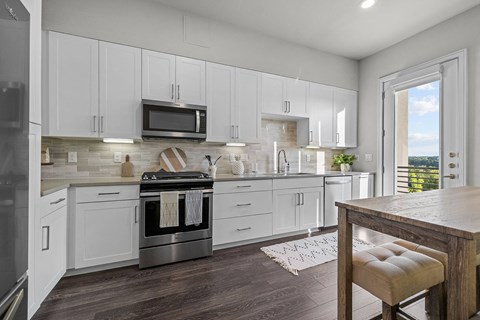 A modern kitchen with white cabinets and a wooden island.