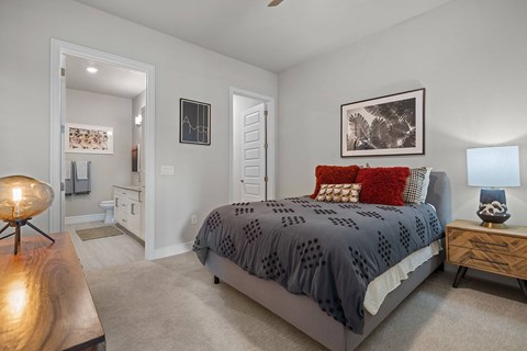 A bedroom with a bed, nightstand, and a lamp.