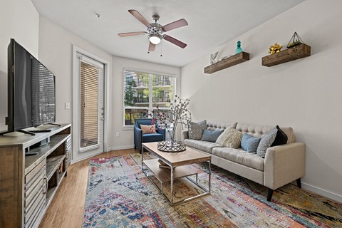a living room with a ceiling fan and a tv