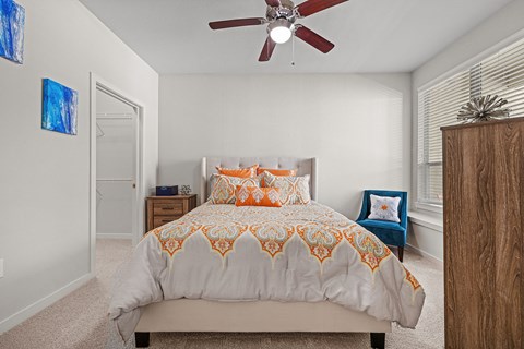 a bedroom with a bed and a ceiling fan