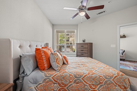 the master bedroom has a large bed and a ceiling fan