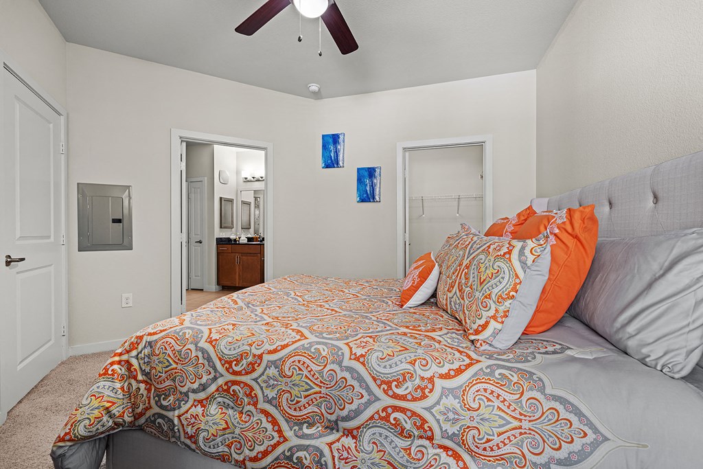 a bedroom with a large bed and a ceiling fan