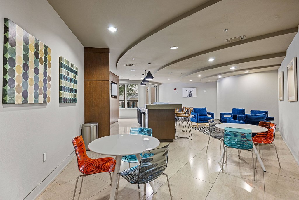 a seating area with tables and chairs in a lobby