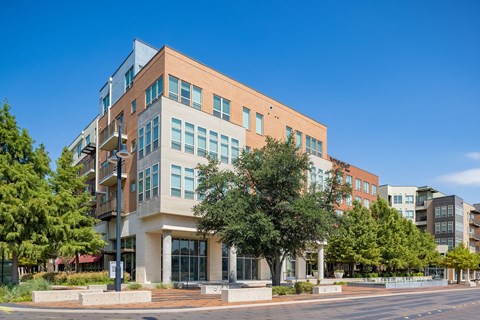 a large building on the corner of a street with trees