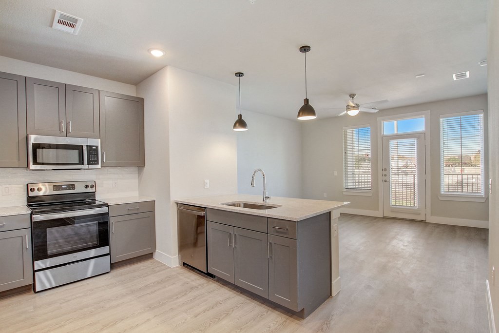 an empty kitchen with stainless steel appliances and a counter top