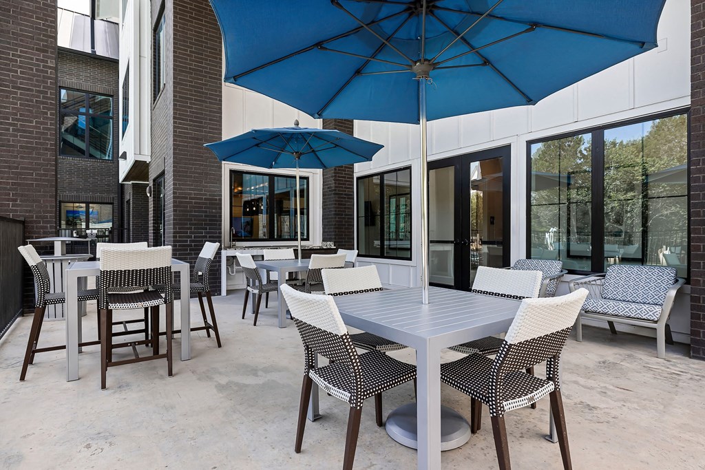 a patio with tables and chairs and umbrellas