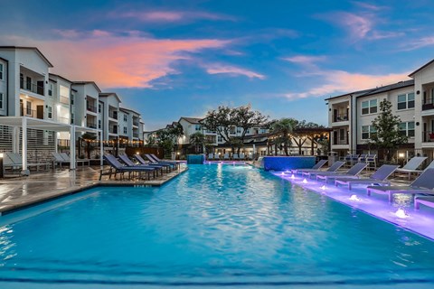 a large swimming pool in front of an apartment building