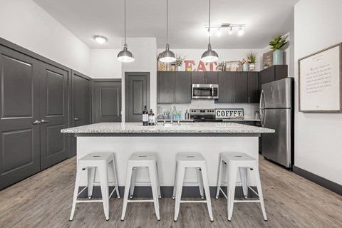 a kitchen with a large island with bar stools