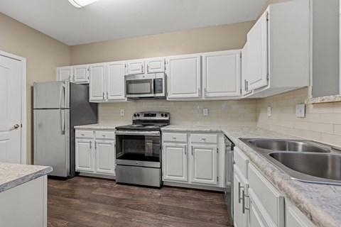 A kitchen with white cabinets and stainless steel appliances.