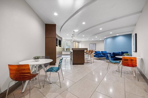 A white table with chairs in a room with a curved ceiling.