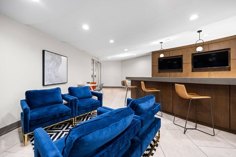 A living room with blue chairs and a television.