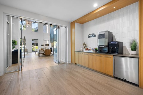 A modern kitchen with wooden floors and stainless steel appliances.