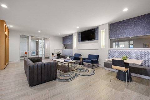 A modern living room with a dark brown sofa, a coffee table, and a TV mounted on the wall.