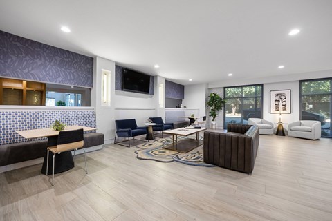 A modern living room with a variety of seating options and a flat screen TV.