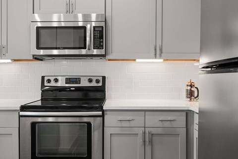 A modern kitchen with a stove top oven and microwave above it.
