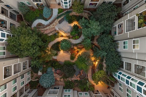 A view of a courtyard surrounded by buildings at night.