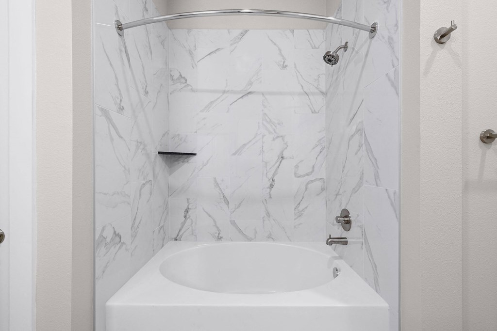 a white bathroom with a tub and a shower