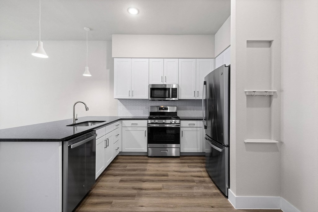 a kitchen with white cabinets and black appliances