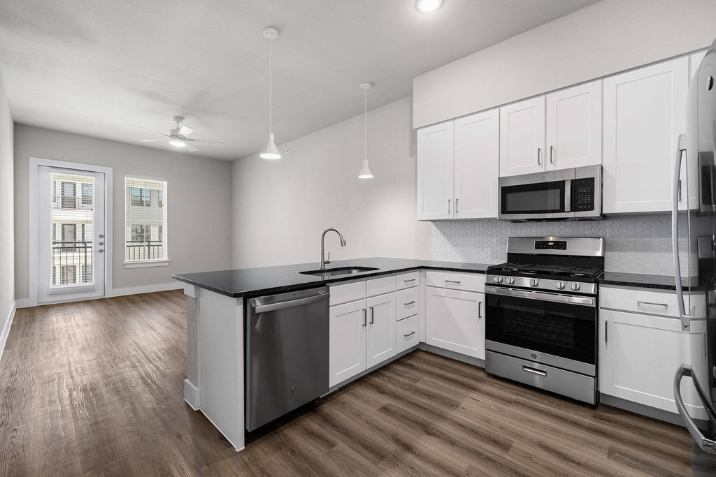 an empty kitchen with white cabinets and stainless steel appliances