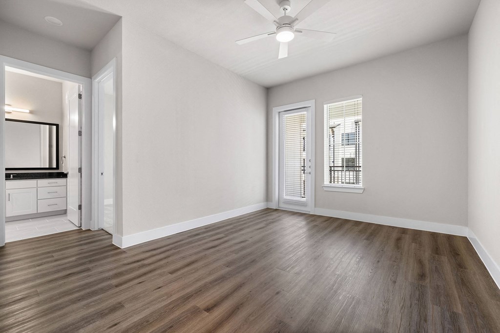an empty living room with white walls and a ceiling fan
