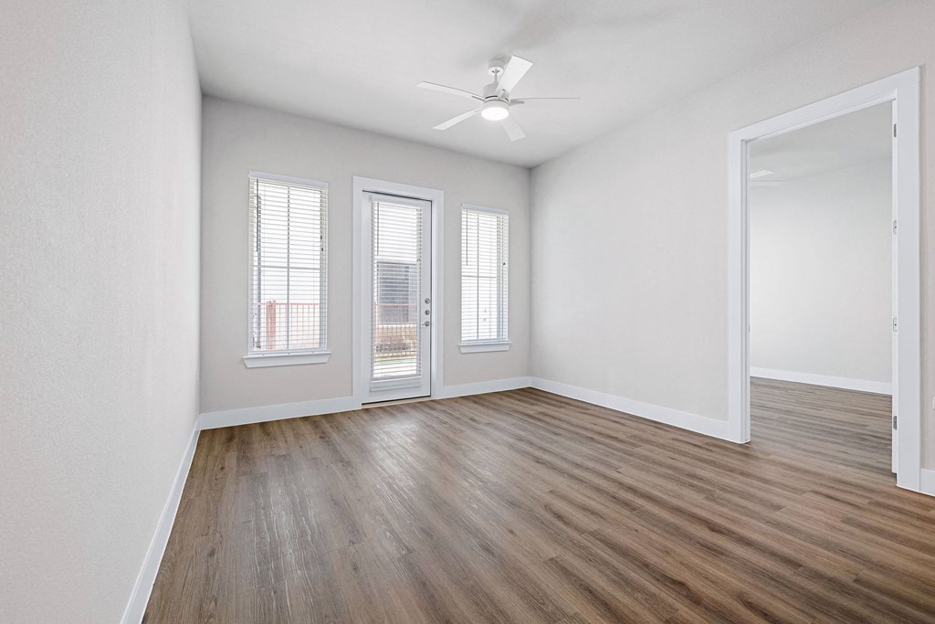 an empty living room with white walls and wood flooring