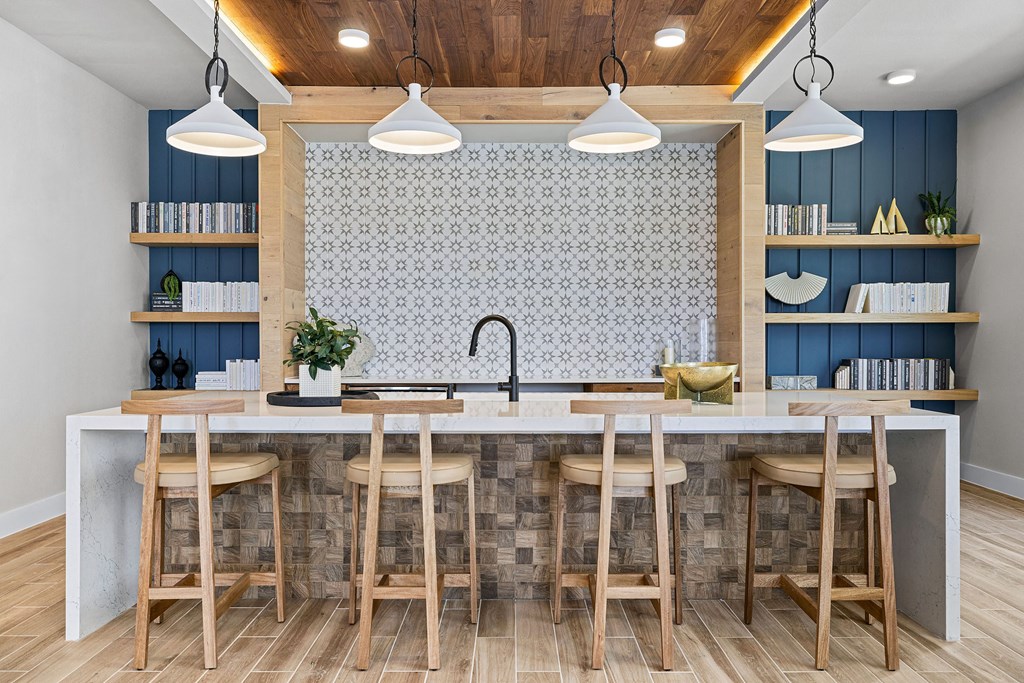 a kitchen with a marble counter top and wooden stools