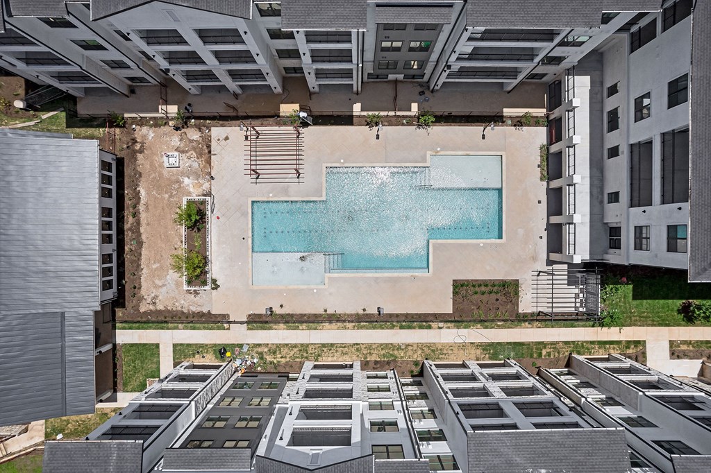 an aerial view of a pool in the middle of an apartment building