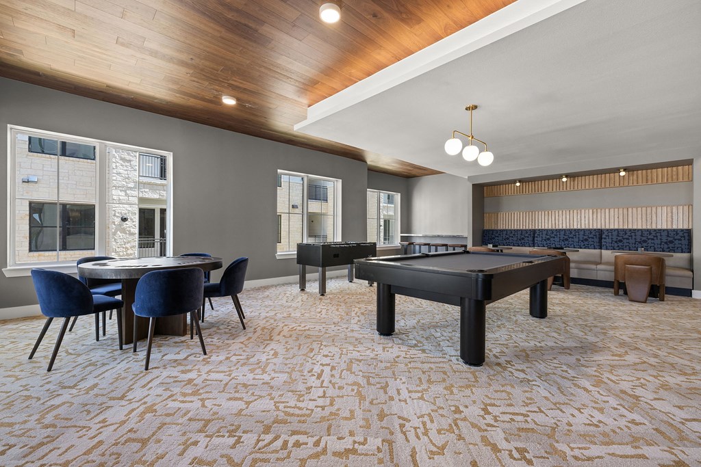 a community room with a pool table and tables