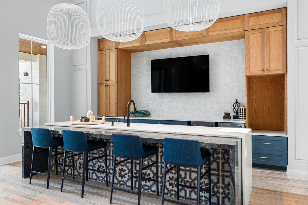 a kitchen with a marble counter top and blue bar stools