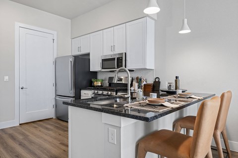 a kitchen with a island and a stove and a refrigerator