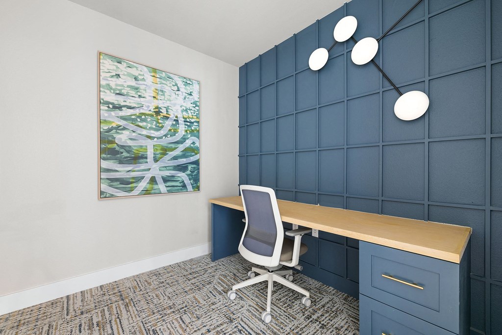 a conference room with blue walls and a desk with a chair